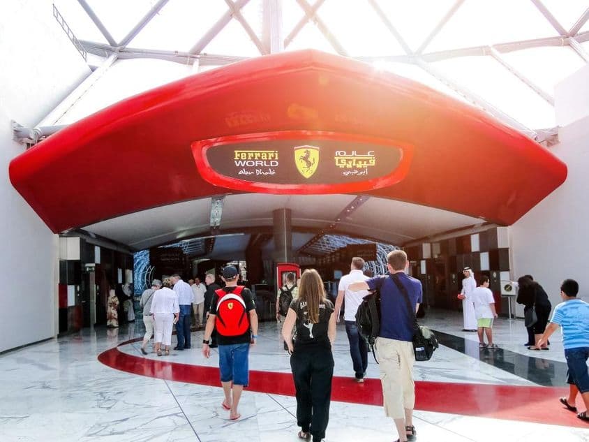 Vchod do Ferrari World Esports Arény v Abu Dhabi, ľudia prechádzajú cez dvere.