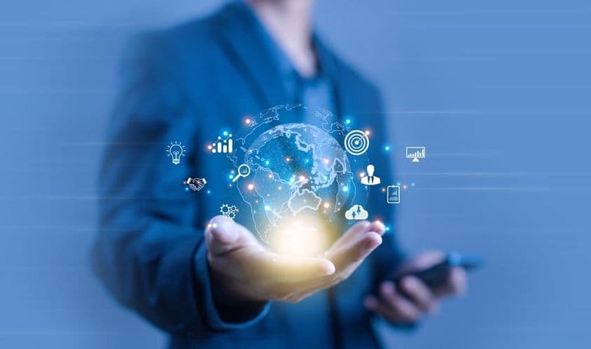 Osoba drží digitálnu projekciu v tvare zemegule.