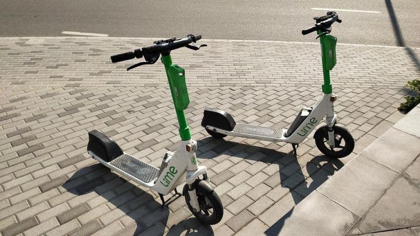 Lime kolobežky stojace na ulici v Dubaji.