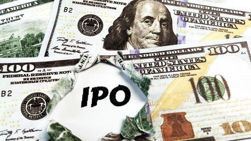 Kúsok papiera s nápisom 'IPO' na vrchu amerických 100 dolárových bankoviek.