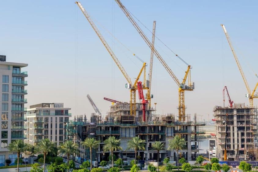 Dubajská výstavba, polovične hotové domy a žeriavy.