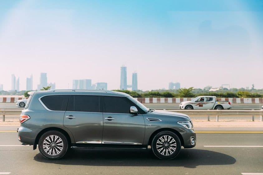 Nissan Patrol v popredí s dubajskými mrakodrapmi v pozadí.