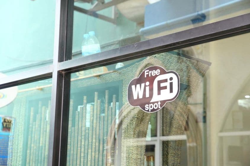 Znak v okne kaviarne propagujúci bezplatné WiFi.