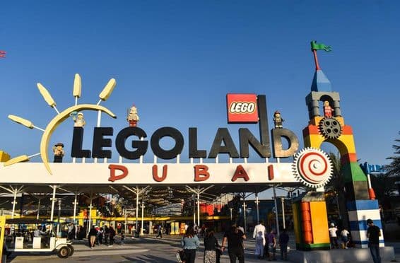 Vstup do LEGOLAND Dubai s ľuďmi a golfový vozík vpredu.