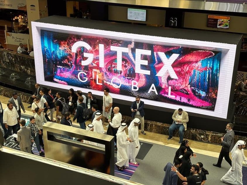 Gitex Global v pozadí s ľuďmi, prevažne mužmi a ženami z Emirátov v popredí.