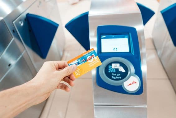 Osoba držiaca limitovanú 10. výročnú Nol kartu pri používaní v metre.