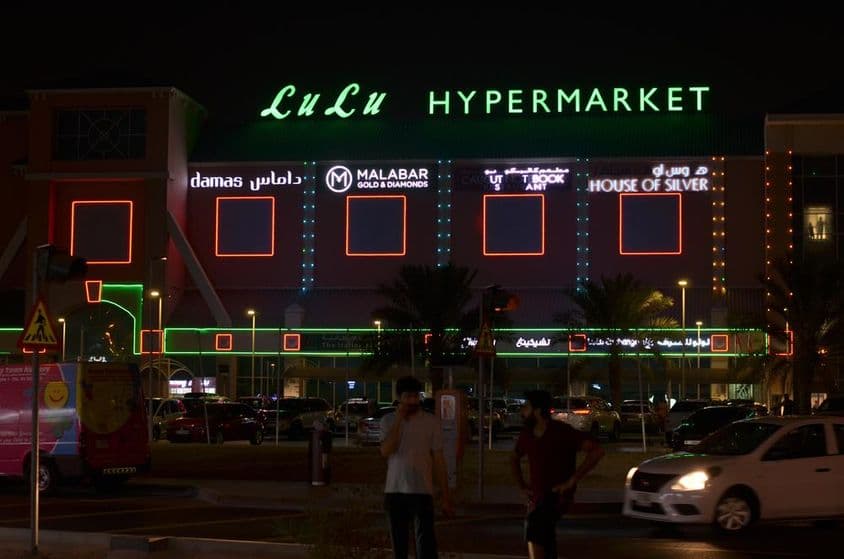 Vstup do hypermarketu Lulu s viditeľným neónovým nápisom nad ním.