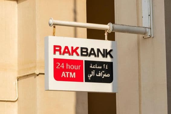 Znak bankomatu RAKBANK v červenom a čiastočne čiernom texte.