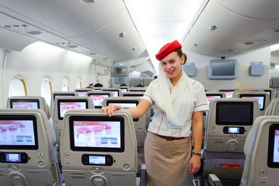 Interiér lietadla Emirates s letušku v popredí.