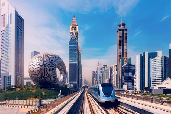 Dubajské metro s mrakodrapmi v pozadí, múzeum budúcnosti na ľavej strane.