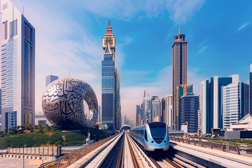 Dubajské metro s mrakodrapmi v pozadí, múzeum budúcnosti na ľavej strane.