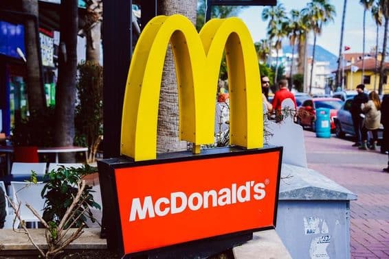 Značka McDonald's viditeľná s pouličným pohľadom na pozadí.