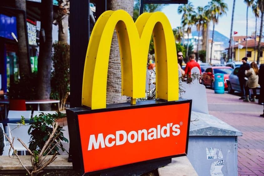 Značka McDonald's viditeľná s pouličným pohľadom na pozadí.