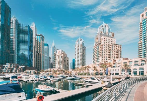 Panoráma Dubaja s prístavom, člnmi a mrakodrapmi v pozadí.