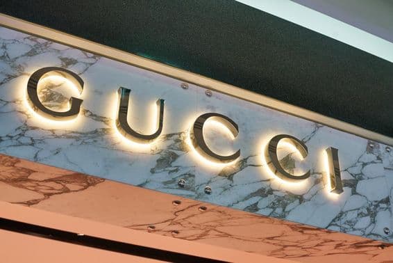 Gucci nápis v osvetlených písmenách na fasáde steny.