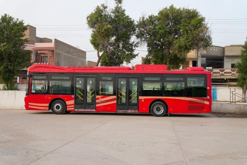 Červený dubajský autobus je zobrazený na parkovisku.