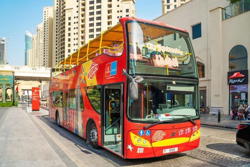 Dubajský On & Off Bus s mrakodrapmi v pozadí.