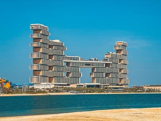 Hotel Atlantis The Royal v pozadí s vodou a plážou v popredí.