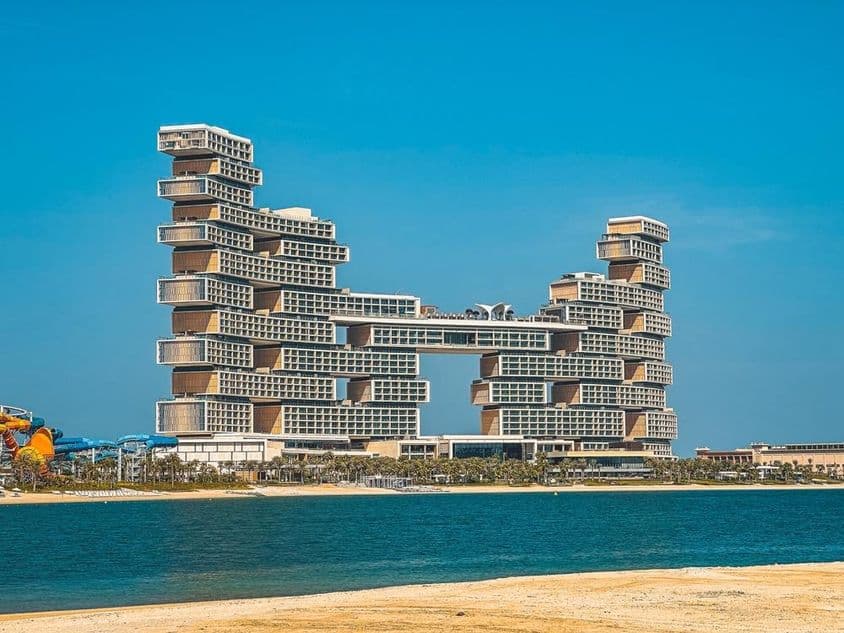 Hotel Atlantis The Royal v pozadí s vodou a plážou v popredí.