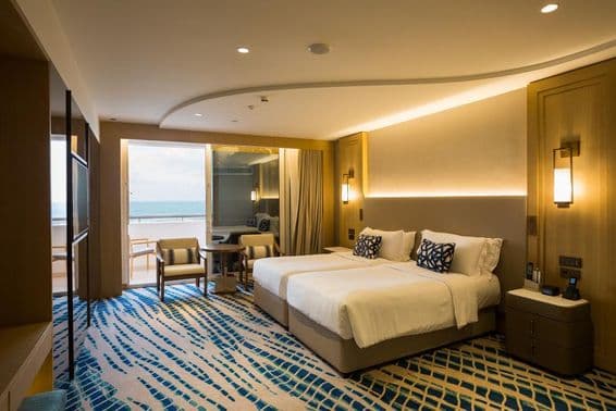 Detail izby v hotelovom apartmáne v Dubaji s posteľou a výhľadom.