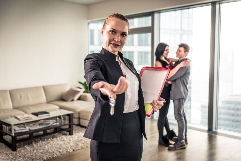 Realitná maklérka máva, párový objatie v pozadí.