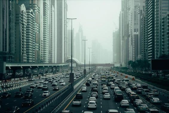 Preplnená diaľnica v Dubaji v meste, 2x7 pruhov, mrakodrapy na oboch stranách.
