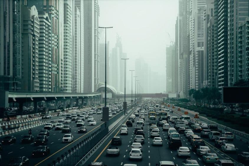 Preplnená diaľnica v Dubaji v meste, 2x7 pruhov, mrakodrapy na oboch stranách.