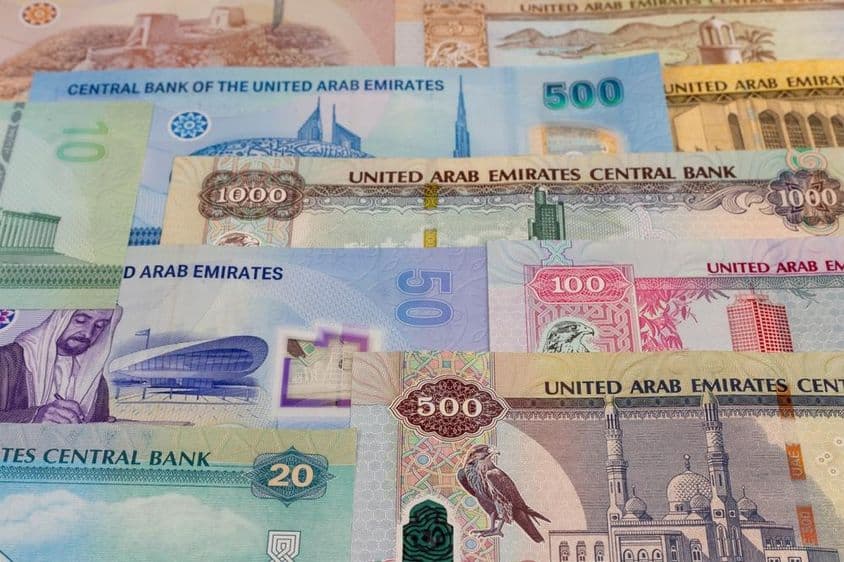 Bankovky v hodnotách 20, 50, 100, 500, 1000 dirhamov na stole.