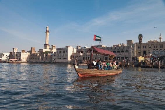 Ľudia sediaci na dubajskej loďke abra.