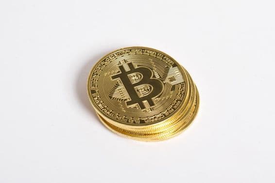 Zlaté Bitcoin mince naukladané na sebe.