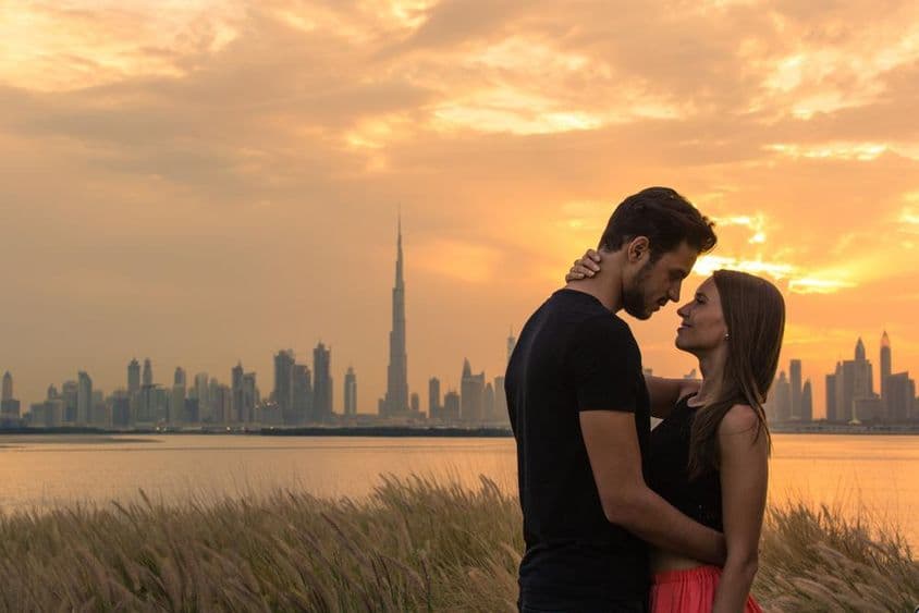Mladý pár s panorámou Dubaja v pozadí.