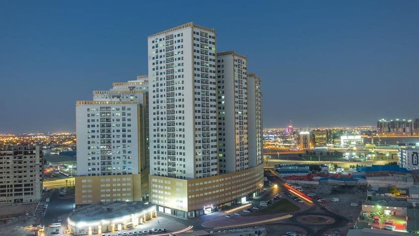 Mesto Ajman s výškovými budovami a strechami.