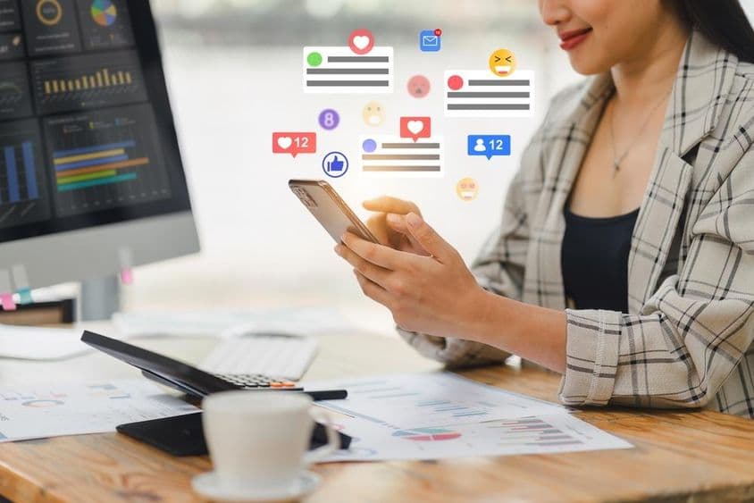 Mladá žena chatujúca cez telefón.