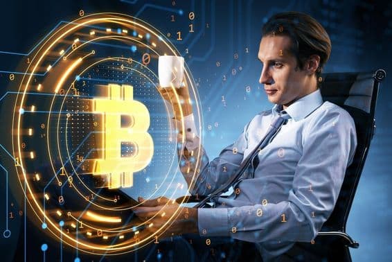 Biznismen s hrnčekom kávy sleduje cenu Bitcoinu.