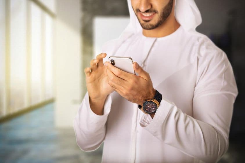 Arab muž používajúci telefón.