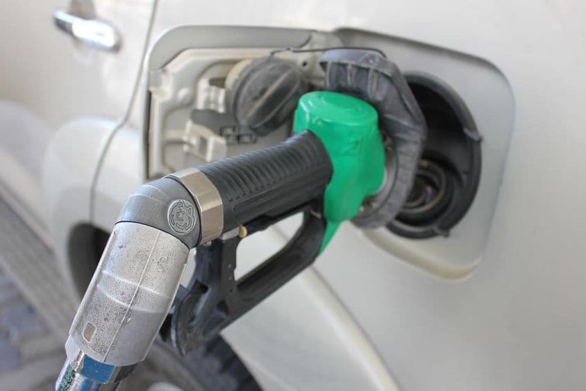 Tankovanie do bieleho auta na čerpacej stanici.