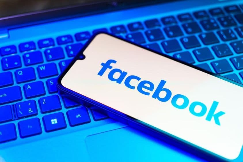 Facebook na telefóne, klávesnica pod ním.