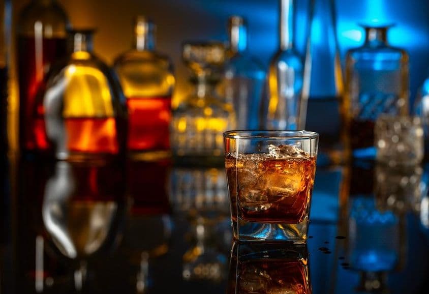 Whiskey s ľadom na čiernom stole v bare.