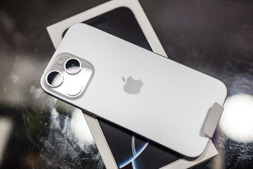 iPhone odpočívajúci na svojej krabici na stole.