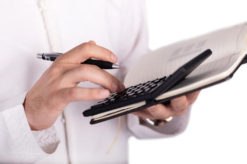 Arabský obchodník držiaci kalkulačku.