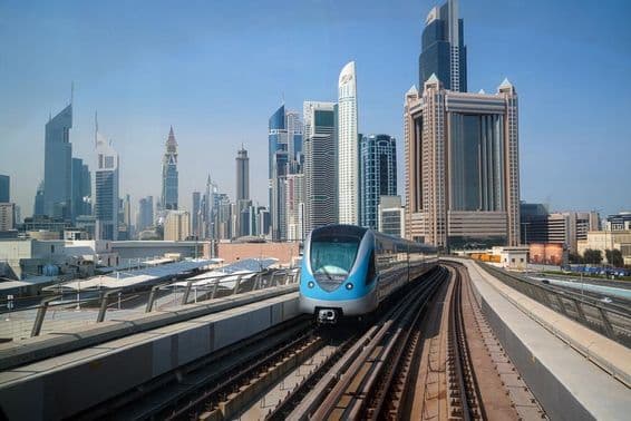 Dubajské metro so mrakodrapmi v pozadí.