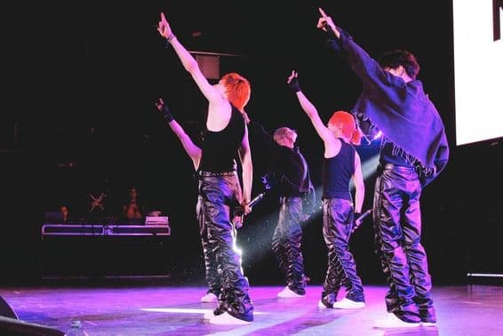 K-Pop skupina tancuje na pódiu.