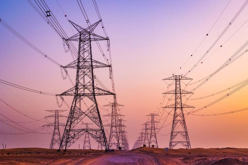 Vysoké napätie veža s elektrickými prenosovými vedením proti farebnej oblohe v púšti Al Qudra, Dubaj, Spojené Arabské Emiráty.