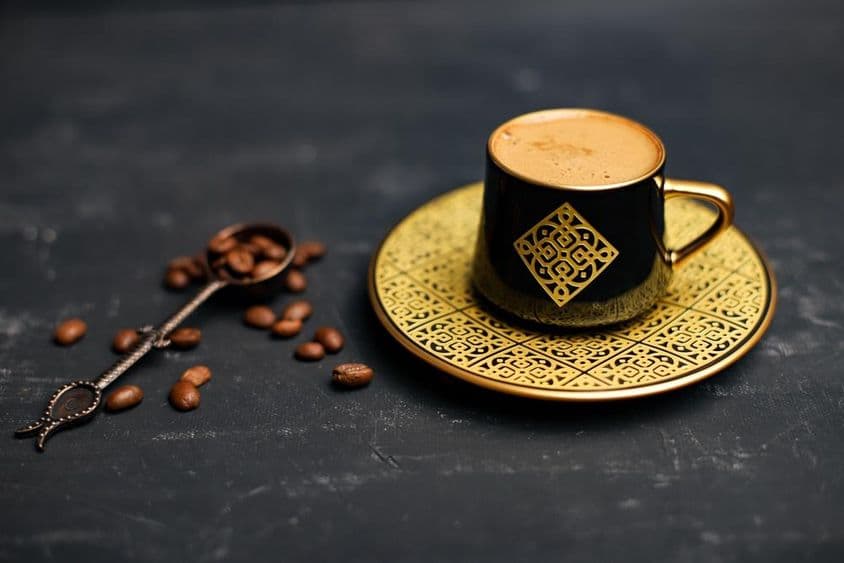 Pozlátený kávový šálok a podšálka.