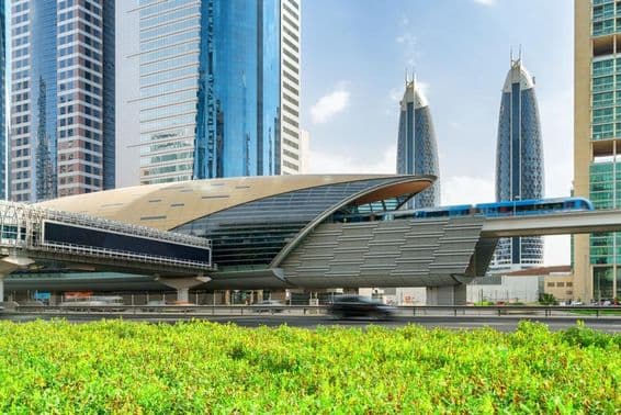 Dubajské metro prichádza na stanicu Financial Centre v centre Dubaja, SAE, s úžasnými mrakodrapmi v pozadí.