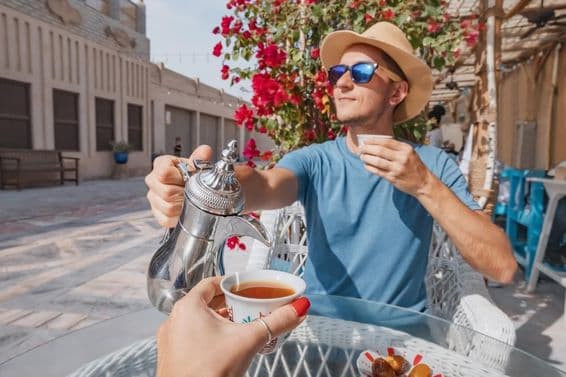 Muž v Dubaji odpočíva v arabskom káve, nalieva aromatickú kávu z dallah kanvice.