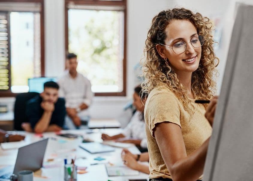 Koučingové stretnutie a prezentácia so ženskou dizajnérkou v kreatívnom pracovnom prostredí na rozvoj zručností.