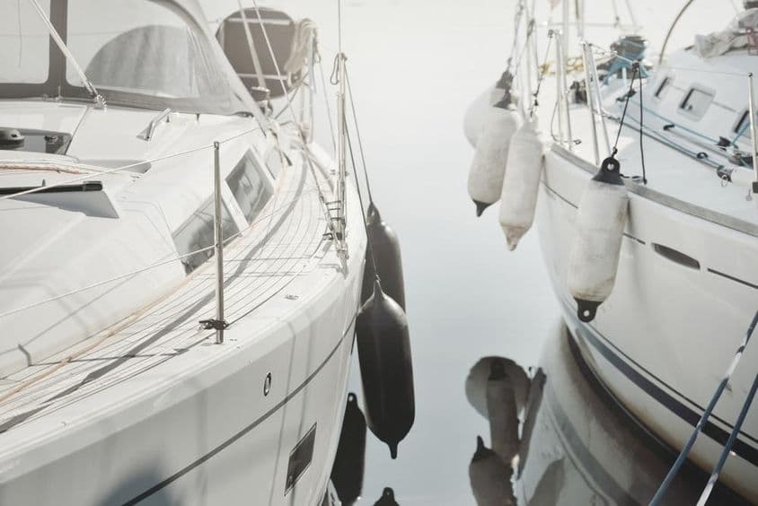 Biela, moderná plachetnica ukotvená v prístave.