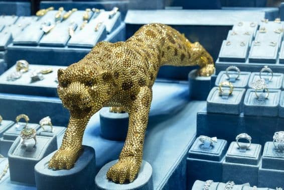 Zlatá leopardia figúrka zdobená diamantmi na zlatom trhu.