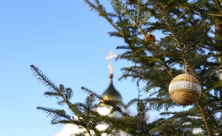 Vetvička vianočného stromčeka s ozdobami, s pravoslávnym krížom v pozadí